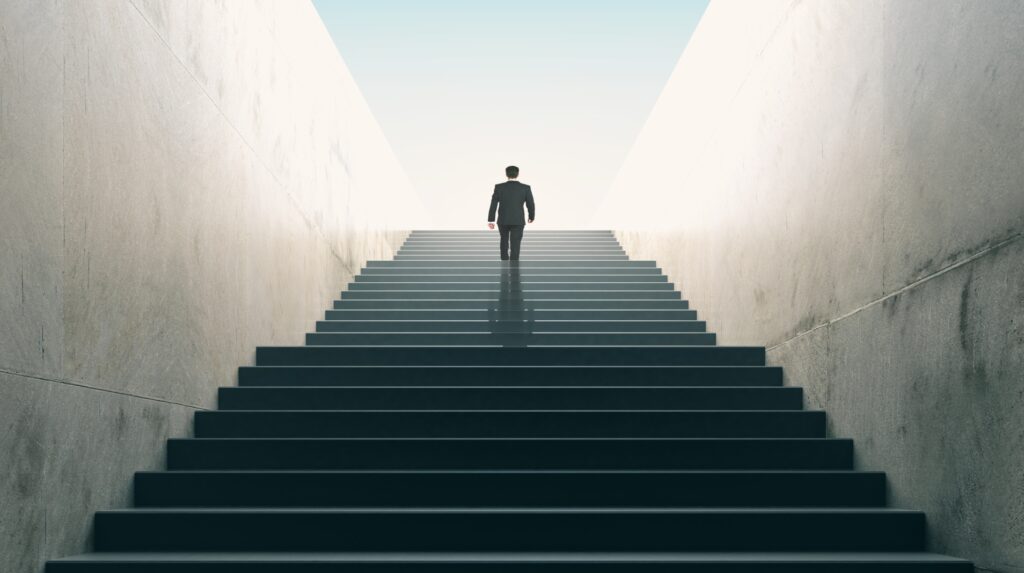 Ambitions concept with businessman climbing stairs