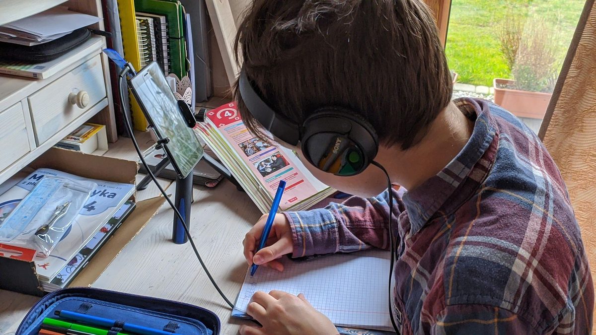Evde kulaklıkla tablet üzerinden ders çalışan öğrenci